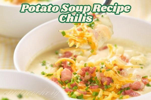 A steaming bowl of creamy potato soup topped with crispy bacon, shredded cheddar cheese, and chopped scallions, served with a side of crusty bread.